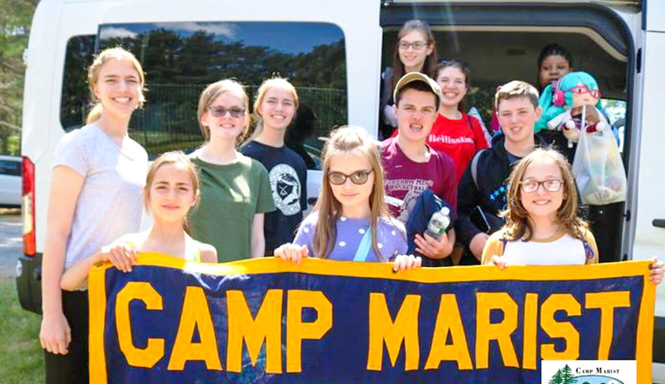 Group of campers hold up Camp Marist banner
