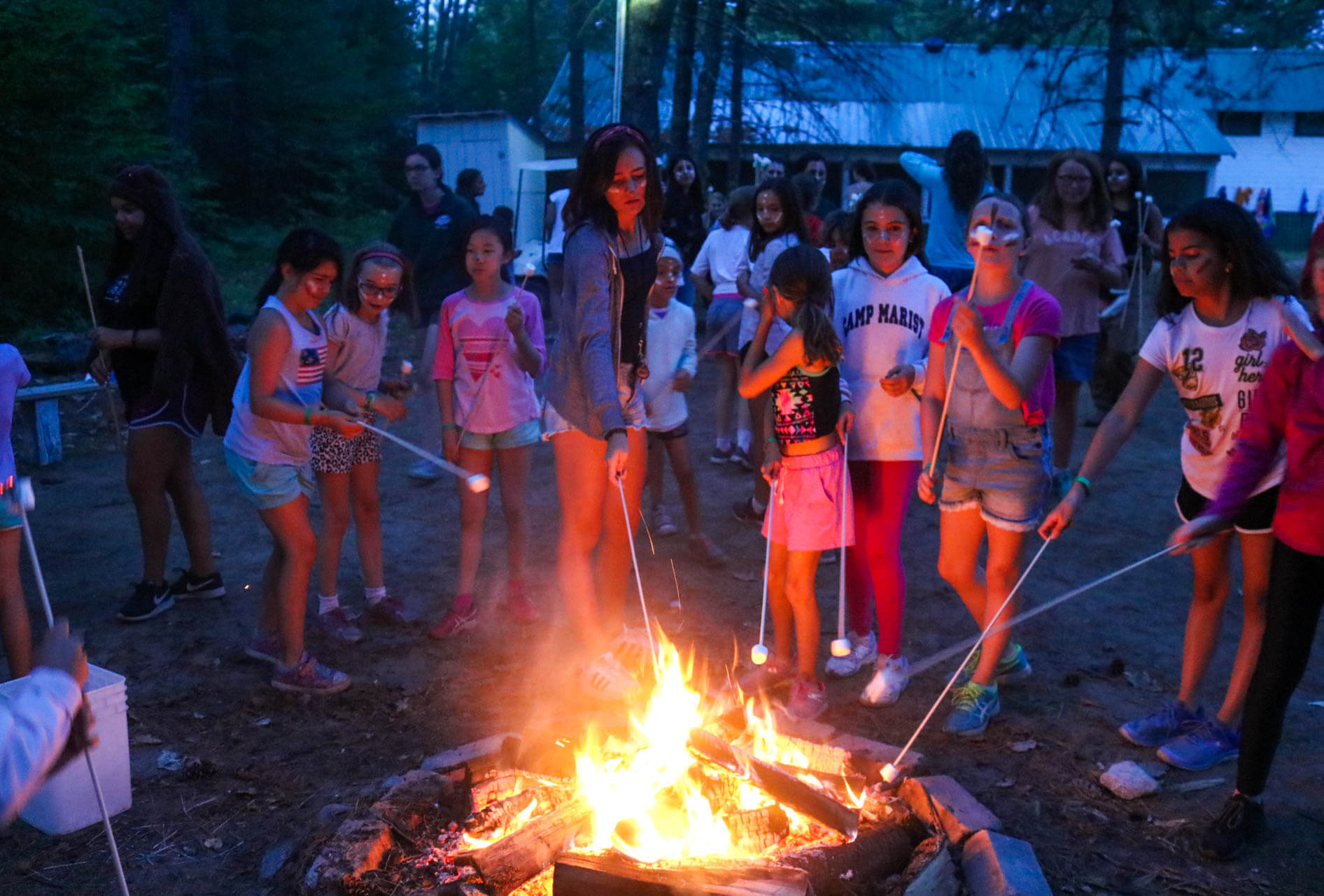 Campers roast marshmallows over fire