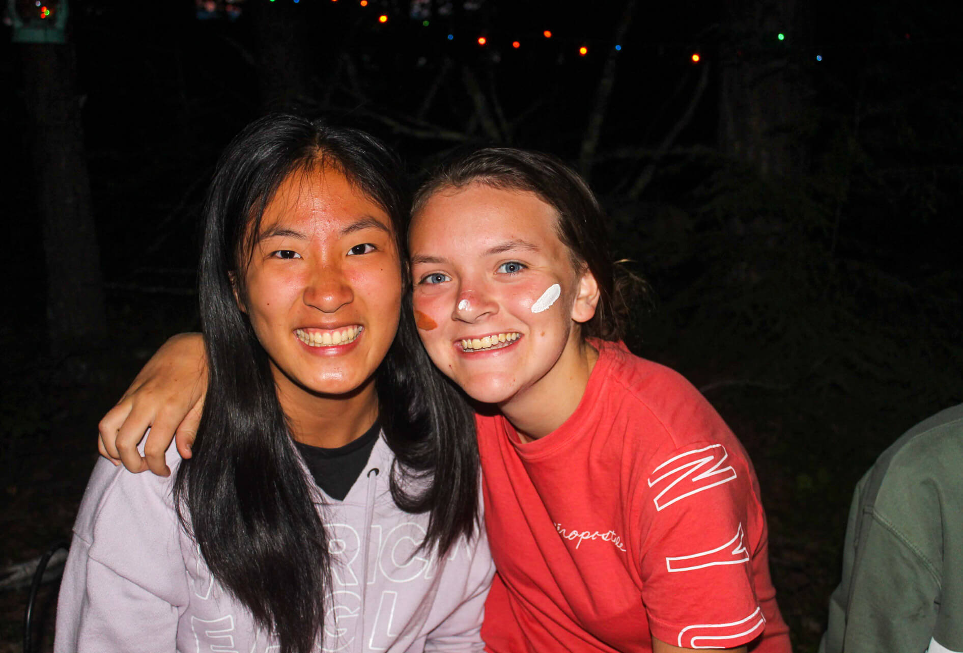 Two smiling campers pose for photo at night