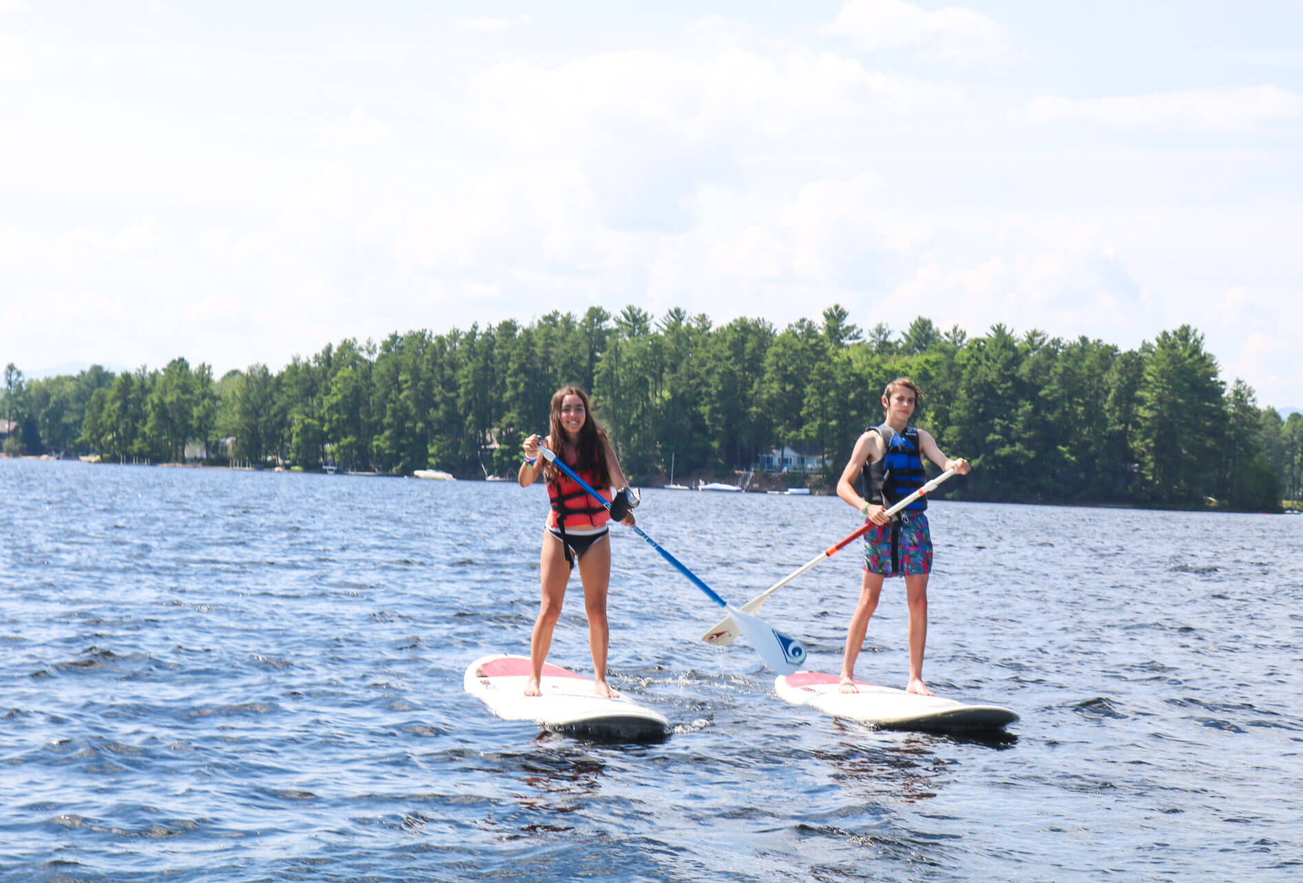 Campers paddle stand-up paddleboards