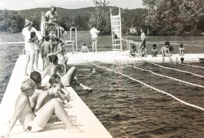 Black and white photo of campers sitting on dock