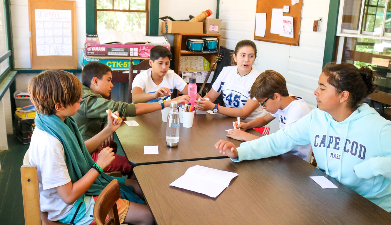 Group of campers sits around table for education activity